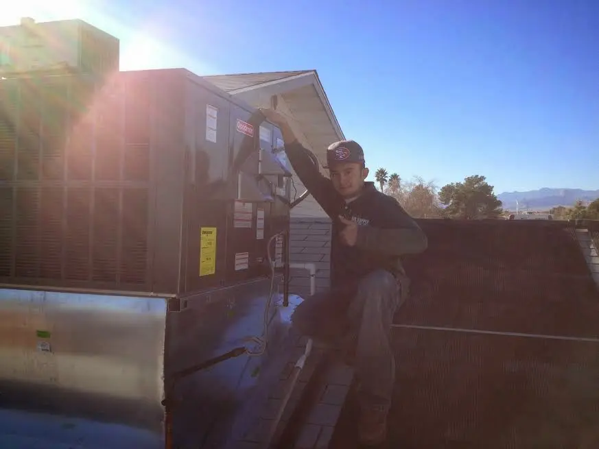 HVAC technician performing HVAC Inspection on a rooftop unit in Pembroke